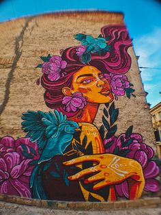 a large mural on the side of a building with flowers in it's hair