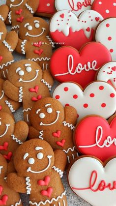 many heart shaped cookies are arranged on a table with hearts and love written on them