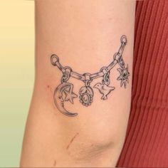 a woman's arm with a chain and stars tattoo on the side of her leg