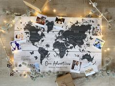 a world map surrounded by photos and christmas lights on a wooden floor with presents wrapped around it