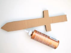 an empty tube of glue next to a cardboard cross