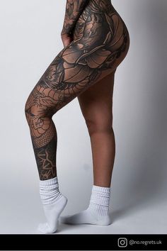 a woman with tattoos on her legs and leggings