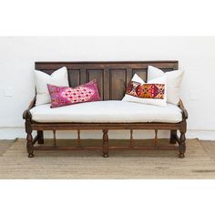 a wooden bench with two pillows on it