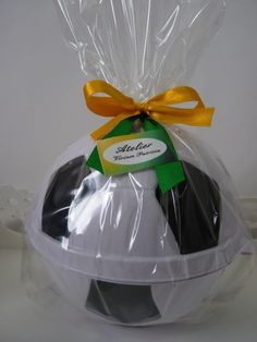 a plastic bag filled with black and white cookies next to a yellow ribbon tied around it