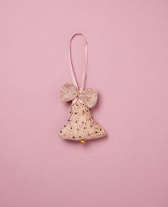 a christmas tree ornament hanging on a pink background