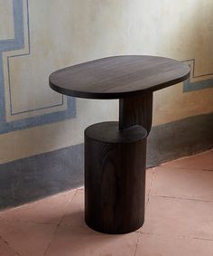 a wooden table sitting on top of a tiled floor