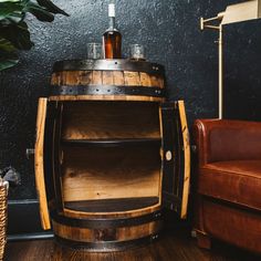 a wooden barrel sitting next to a leather chair