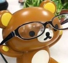 a brown teddy bear wearing glasses on top of a table