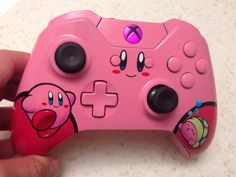 a close up of a pink controller with cartoon characters on the front and back buttons