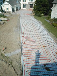 a man is standing in front of a house with an electrical heating system on the ground