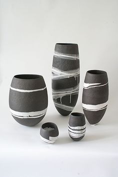 several black and white vases sitting next to each other