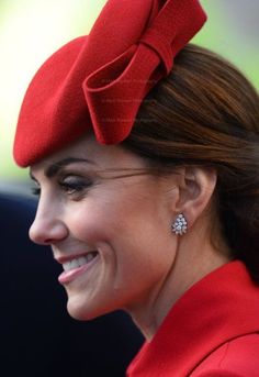 a woman wearing a red hat with a big bow on it's head and smiling