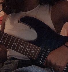 a woman is playing an electric guitar