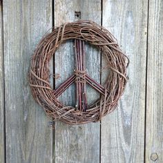 a peace sign made out of twigs on a wooden fence