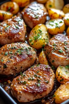 some meat and potatoes in a pan with seasoning sprinkled on top for garnish