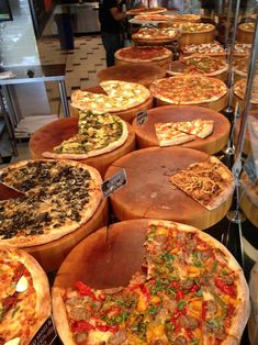 many different types of pizza on display in a store