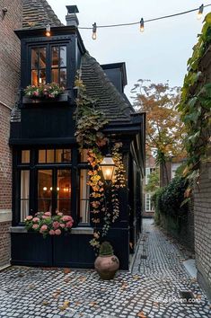 a black building with lots of windows and flowers in the window boxes on the side