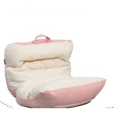 a pink and white pillow sitting on top of a chair