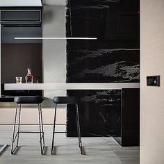 two bar stools sit in front of a counter