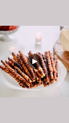 there is a white plate that has several skewers of food on it, and the video shows how to make skewers