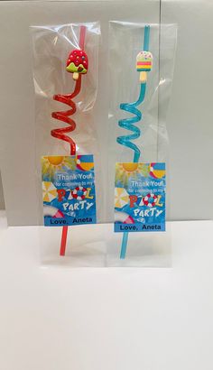 two plastic toothbrushes with straws on them