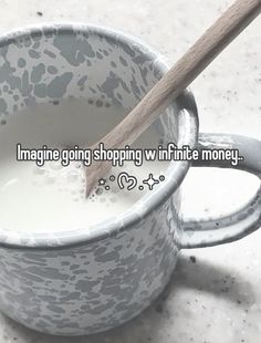 a cup filled with milk next to a wooden spoon