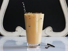 a glass filled with liquid sitting on top of a table