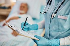 a nurse writing on a clipboard while holding a pen and paper in her hand