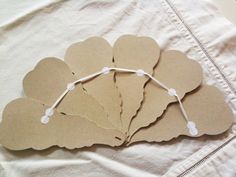 several pieces of cardboard with string attached to them on a white sheeted bed spread