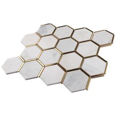 three hexagonal marble tiles with gold trimmings on each side, one white and