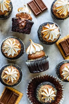 chocolate cupcakes with white frosting and star decorations on top are arranged in rows