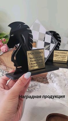 a person holding up a trophy in front of a table with flowers and other items