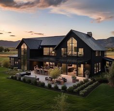 an aerial view of a modern house with large patio and outdoor dining area at dusk