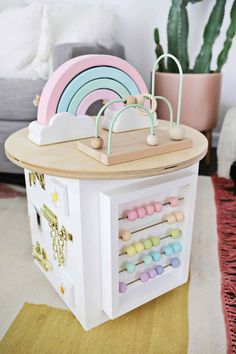 a toy house with toys in it and a rainbow on the table next to it