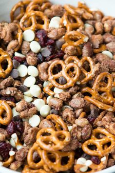 a white bowl filled with cereal and pretzels