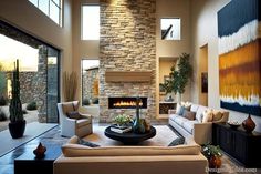 a living room filled with furniture and a fire place in the middle of it's wall