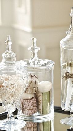 two clear glass bottles sitting on top of a metal tray