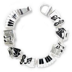 a silver bracelet with black and white charms on it's sides, featuring musical instruments