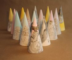 a group of small white and pink cones with gold glitters on them, lined up against a brown background