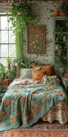 a bed with green and orange bedspread in a room filled with potted plants