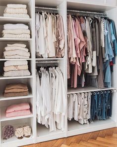 an organized closet filled with clothes and folded shirts