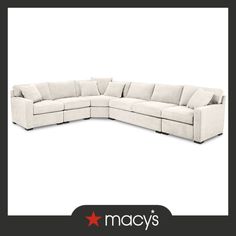 a large sectional couch with pillows on the top and bottom corner, in white linen