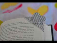 an origami bookmark is folded in half and placed on top of an open book