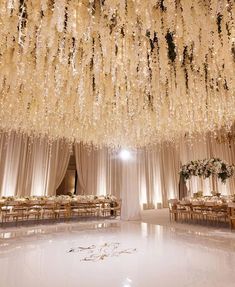 the ceiling is covered with white flowers and chandeliers