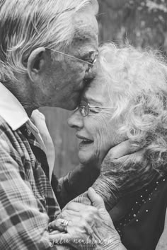 an older couple kissing each other in black and white