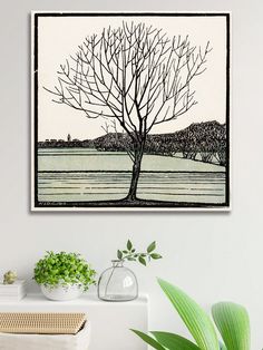 a painting hanging on the wall next to a potted plant