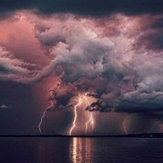 a storm is coming over the water and it appears to be lightning striking in the sky