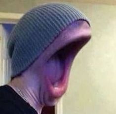 a man with his mouth open and wearing a beanie on top of his head