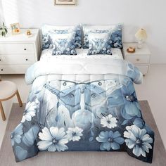 a bed with blue and white flowers on it in a room next to a dresser