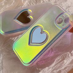 two phone cases with heart cutouts on them, one has a hole in the middle